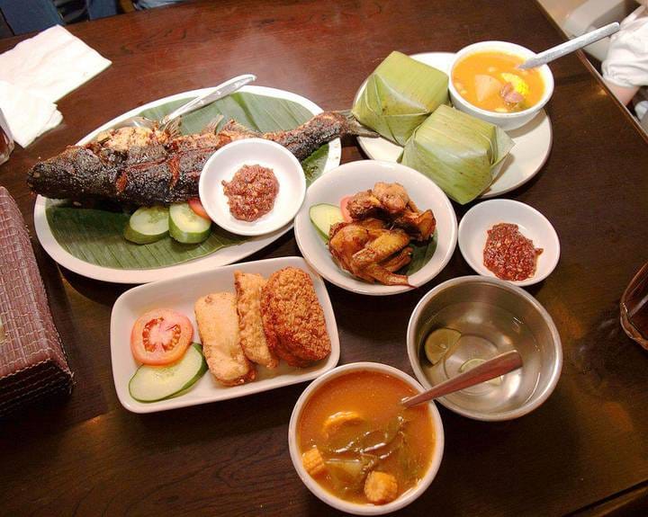 Aneka makanan sehat sederhana seperti nasi, sayur, buah, dan tempe di atas meja.